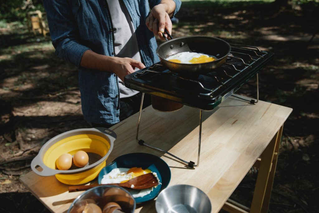 a man cooks eggs on the grill