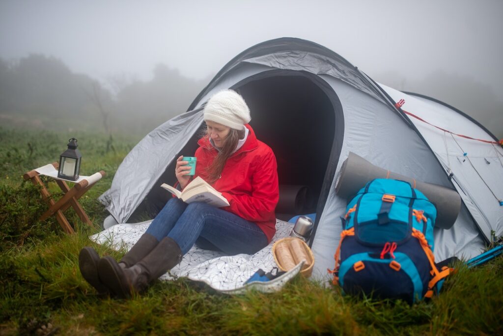 A women reads near her tent