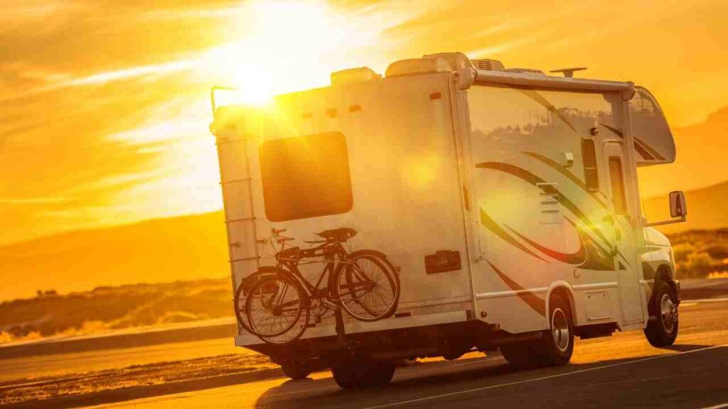 An RV drives down the road at sunset