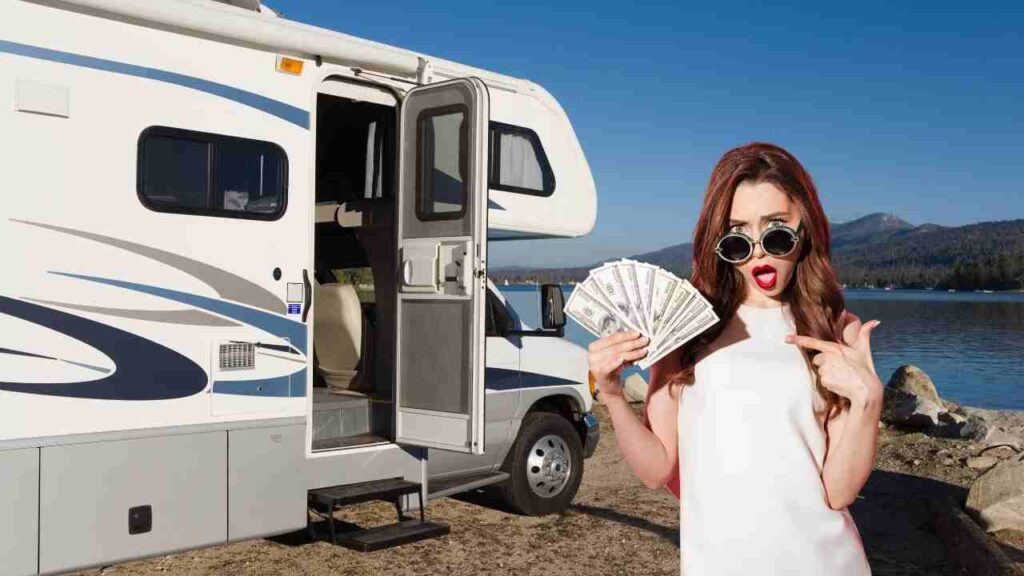A woman points to a wad of money in front of an RV
