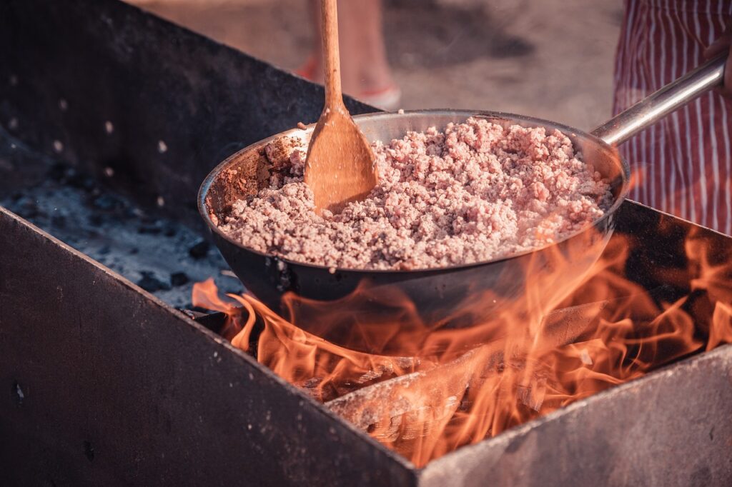 Cooking over a fire with a wooden spoon