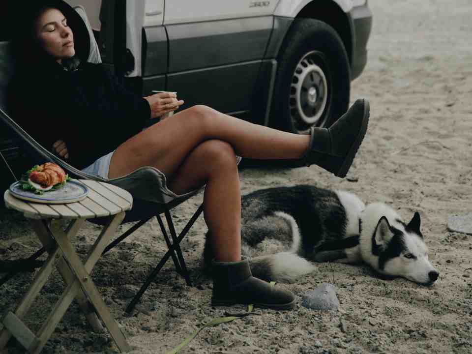 a woman camps with a huskey