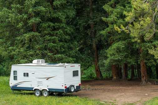 a travel trailer sits alone in the woods